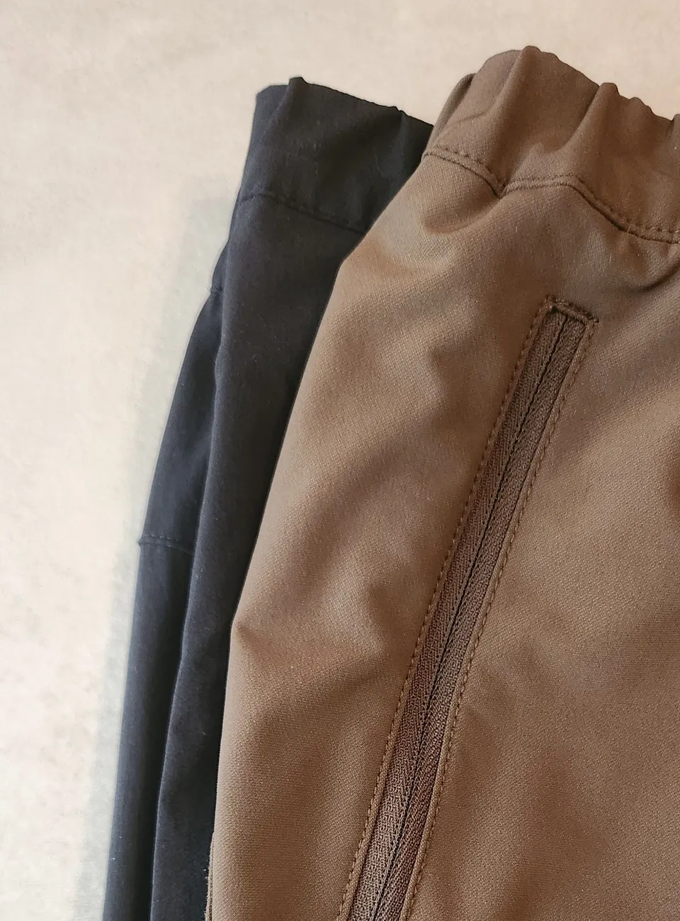 3本のパンツを右側でそろえて重ねた写真。左に出ているほどウエストとヒップが大きく、左からフレキシブルアンクル、バーブライトスリム、ブラウンのアルパインライト