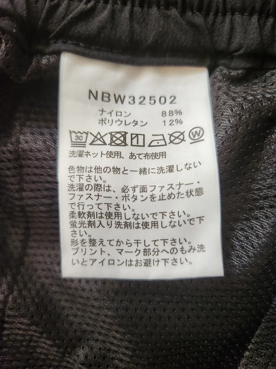 バーブライトスリムパンツの品質表示。NBW32502、ナイロン88%・ポリウレタン12%、柔軟剤・蛍光剤入り洗剤は使用しない